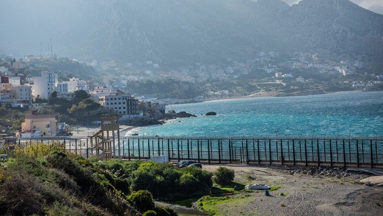 The fence, eight kilometers long and ten meters high, marking the border between Ceuta and Morocco, reaches all the way to the edge of the sea. (Giovanni Culmone/GSF)