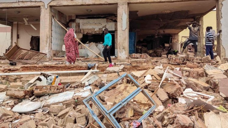 People inspect the rubble of a house hit by an artillery shell in Khartoum