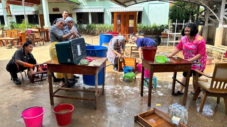 Volunteers clean mud at Santi Witthaya Diocesan School (Photo by Chiang Rai Diocese)