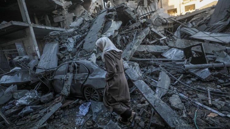 A woman walks among rubble following an Israeli airstrike in the Al Nuseirat refugee camp on December 13.